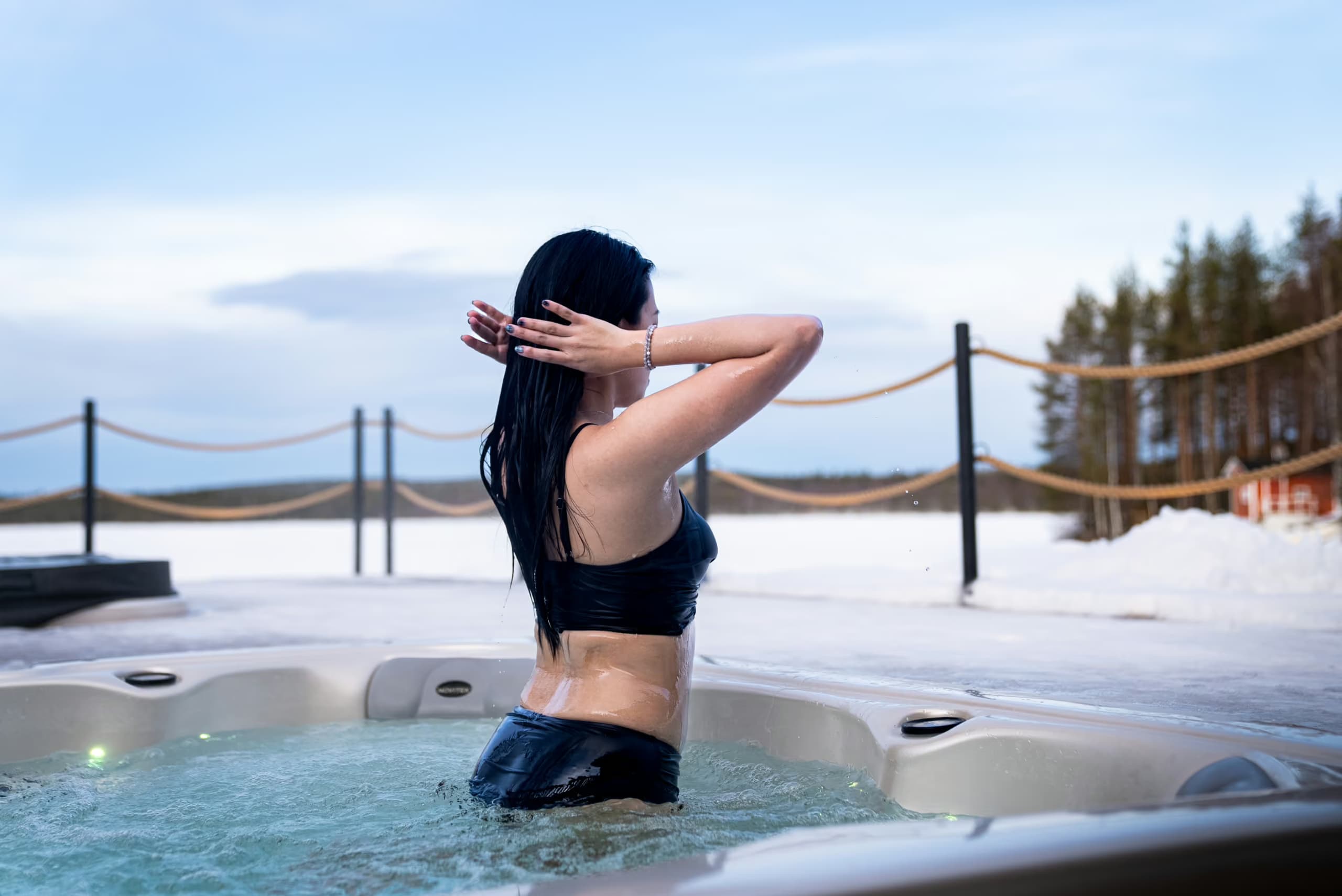 Woman enjoying a lakeside jaccuzi in winter at Aito Resort