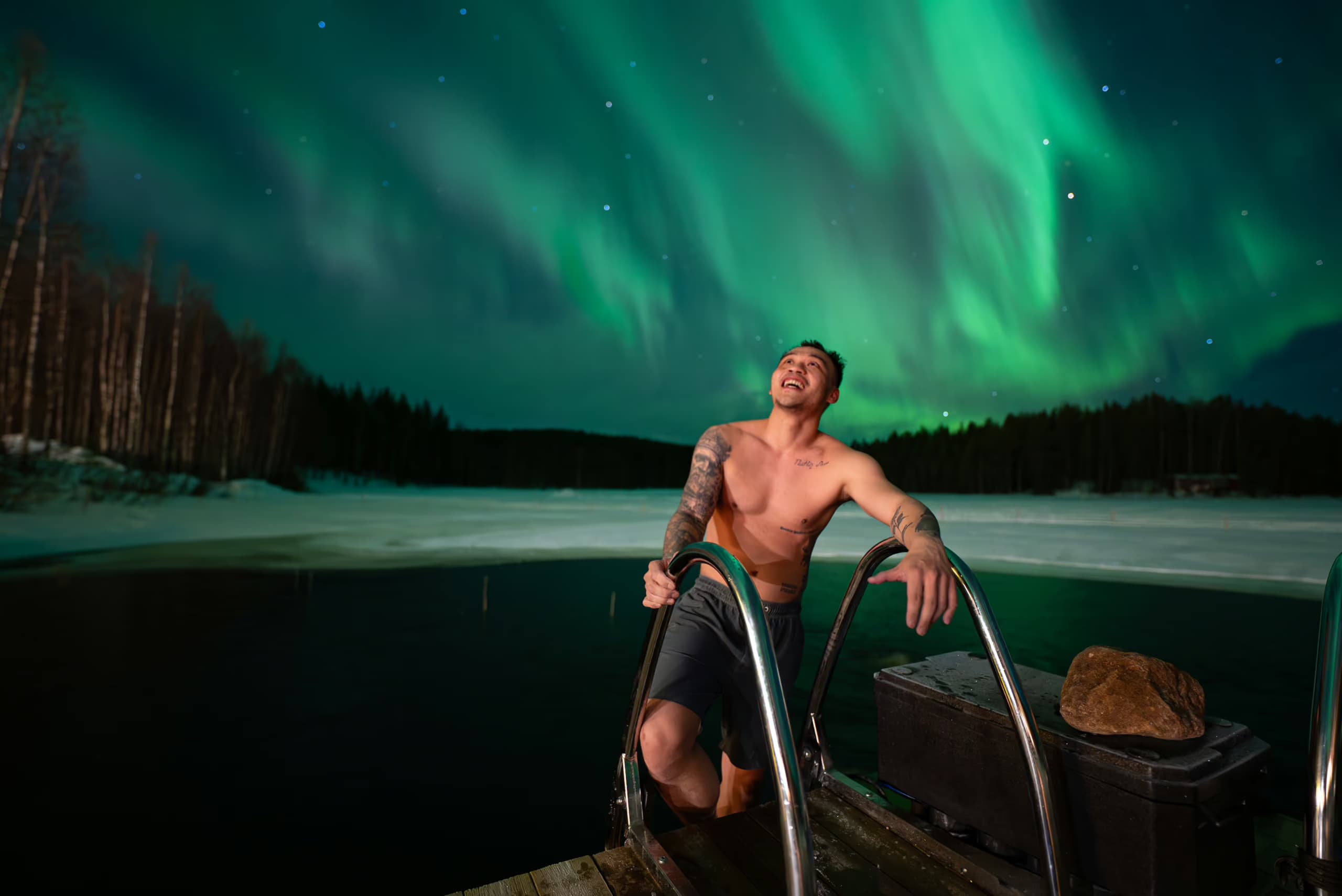 uest preparing for an ice bath in Lake Palojärvi beneath the Northern Lights