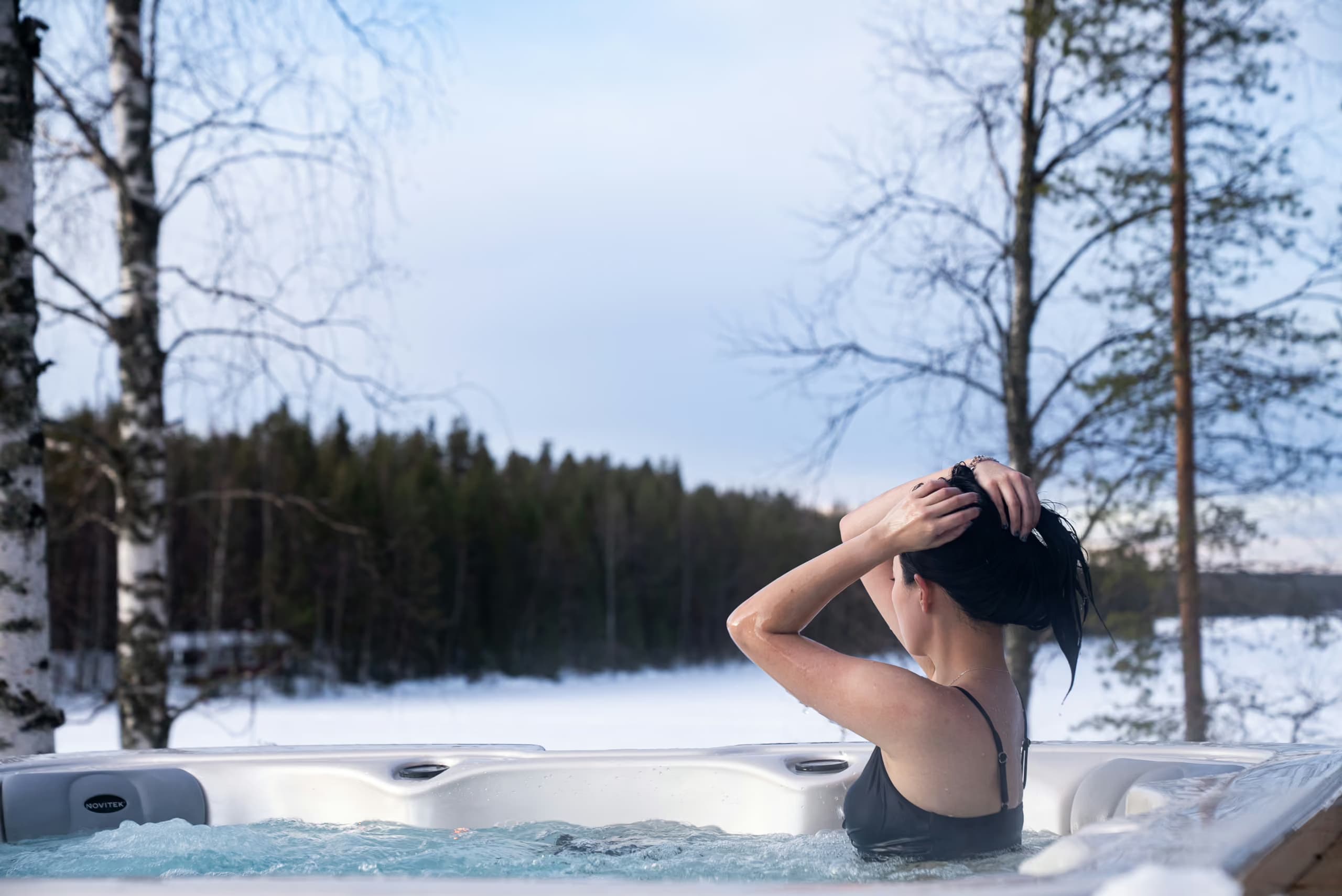 Woman enjoying a lakeview jaccuzi in winter at Aito Resort