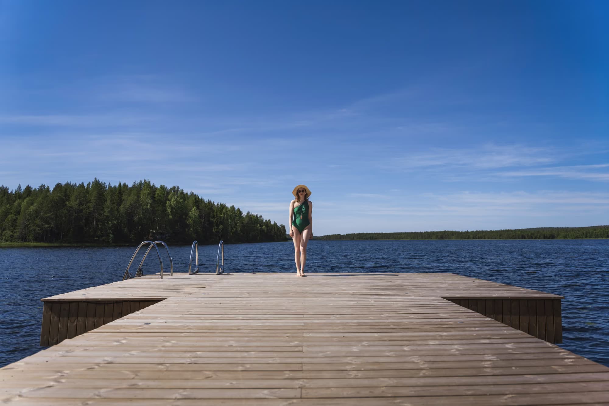 Woman standing on Aito Resort's pier, at Lake Palojärvi