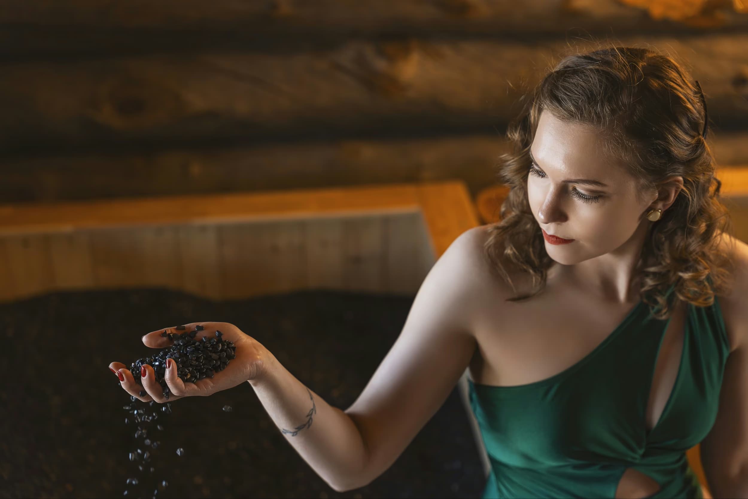 Woman sprinkling crushed jade in a sand bath at Aito Resort