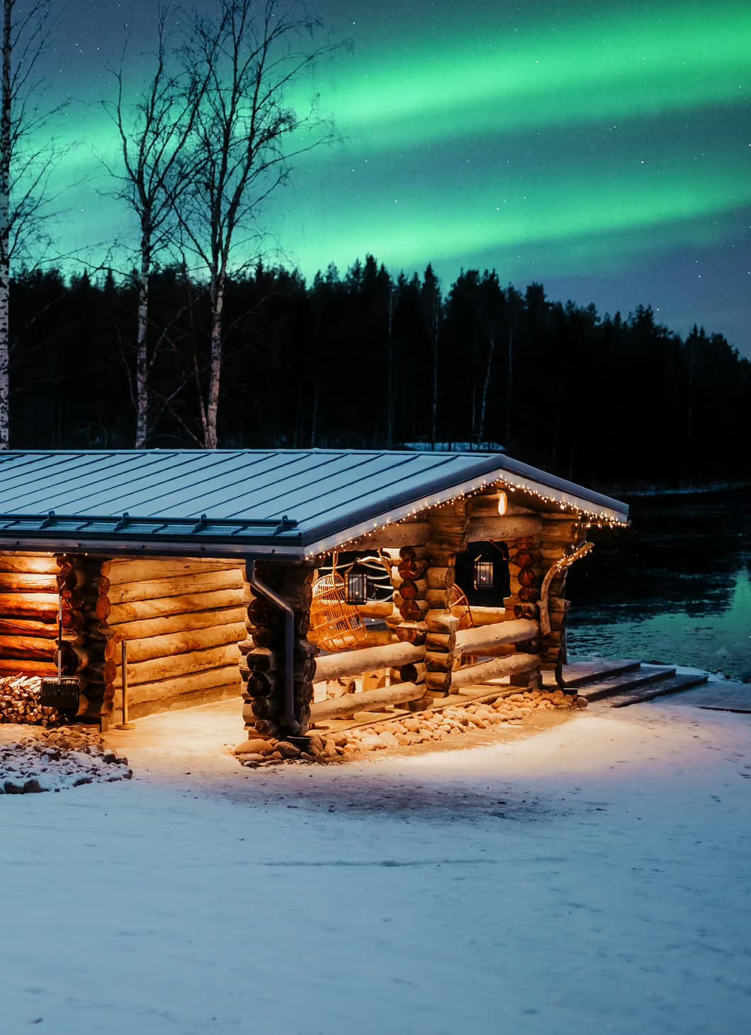 Lakeside sauna building at Aito Resort with northern lights