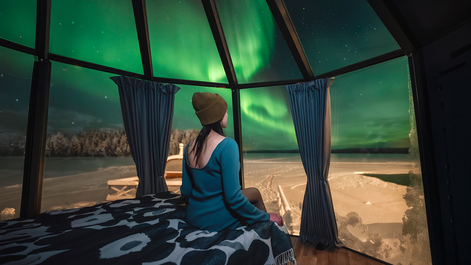 Woman is sitting in the Aurora nest and watching the northern lights