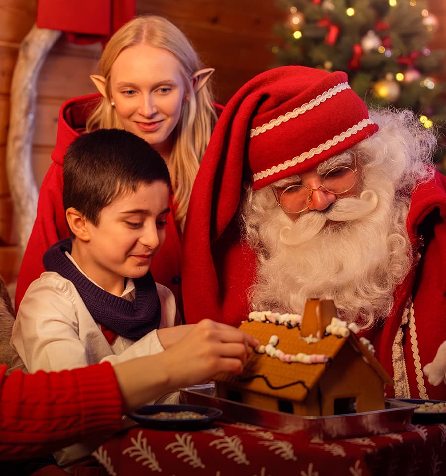 Santa Claus, Elves and child are making ginger bread house