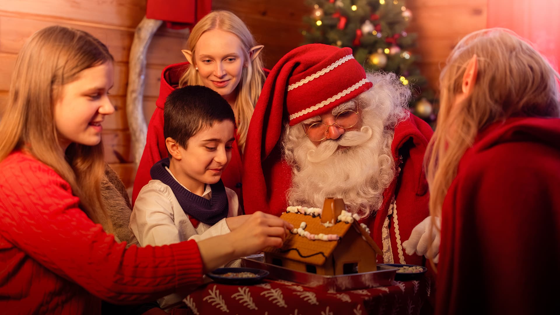 Santa Claus, Elves and child are making ginger bread house